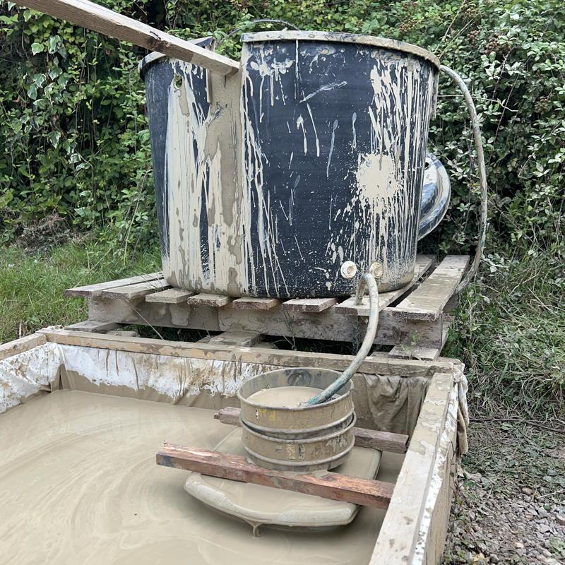slurry being siphoned into the settling tank