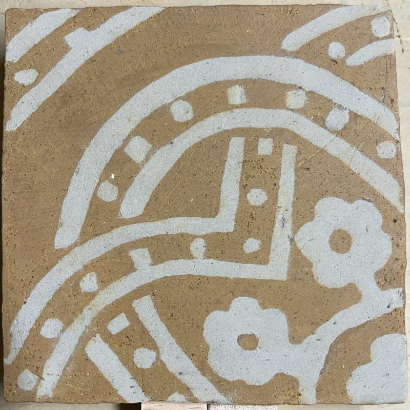 A tile after scraping back to reveal the pattern
